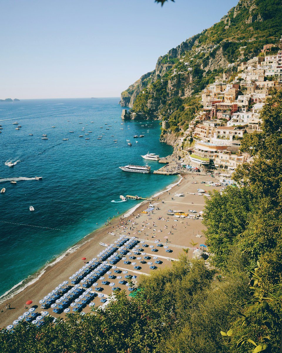 Boats in turquoise water below Positano on the Amalfi Coast